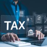 Income,Tax,,Businessman,Calculates,Taxes,Using,Calculator,And,Laptop.,Icons